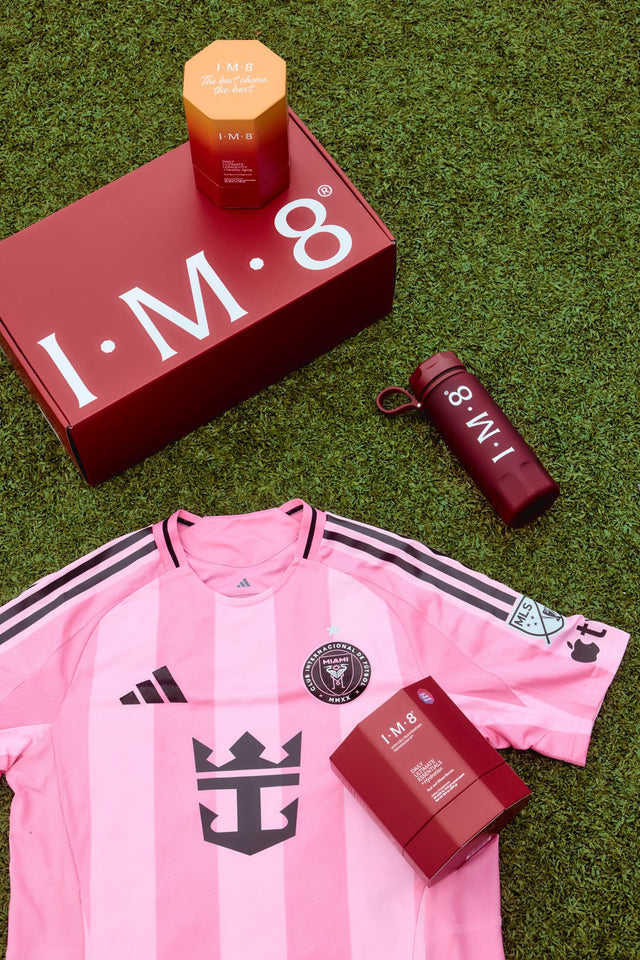 IM8 product line + travel bottle on pitch grass